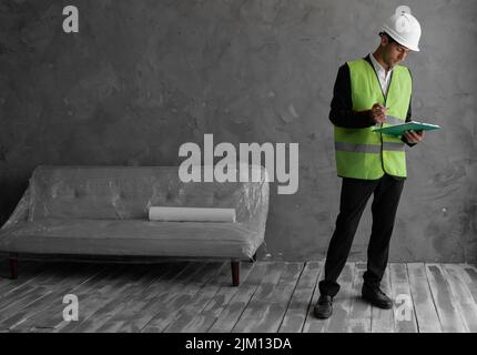 Contremaître arabe constructeur, ingénieur ou inspecteur en matière de sécurité contrôle et inspection par réflexion avec la planchette à pince à l'intérieur du bâtiment du chantier de construction Banque D'Images