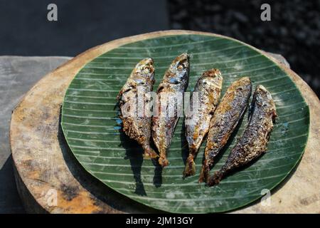 authentique nourriture indonésienne poisson salé frit ou ikan asin gereh sur une surface en bois avec feuille de banane. Banque D'Images