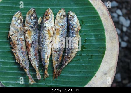 authentique nourriture indonésienne poisson salé frit ou ikan asin gereh sur une surface en bois avec feuille de banane. Banque D'Images