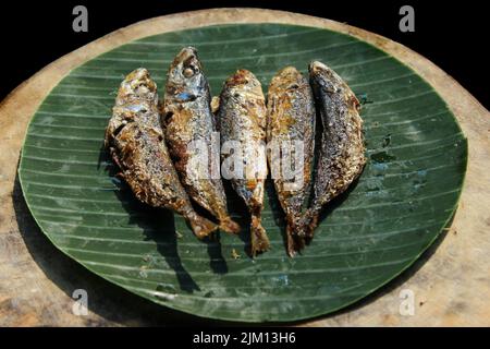 authentique nourriture indonésienne poisson salé frit ou ikan asin gereh sur une surface en bois avec feuille de banane. Banque D'Images