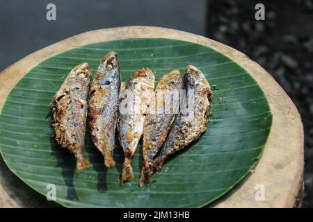 authentique nourriture indonésienne poisson salé frit ou ikan asin gereh sur une surface en bois avec feuille de banane. Banque D'Images