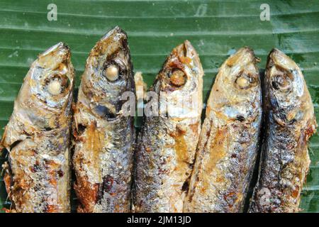 authentique nourriture indonésienne poisson salé frit ou ikan asin gereh sur une surface en bois avec feuille de banane. Banque D'Images