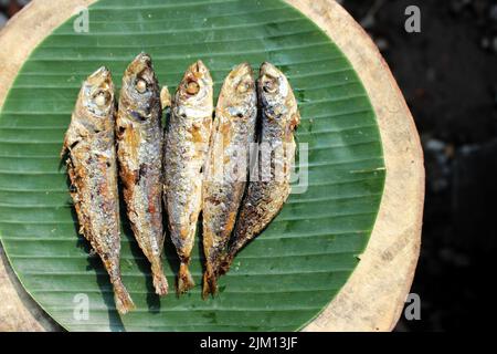 authentique nourriture indonésienne poisson salé frit ou ikan asin gereh sur une surface en bois avec feuille de banane. Banque D'Images