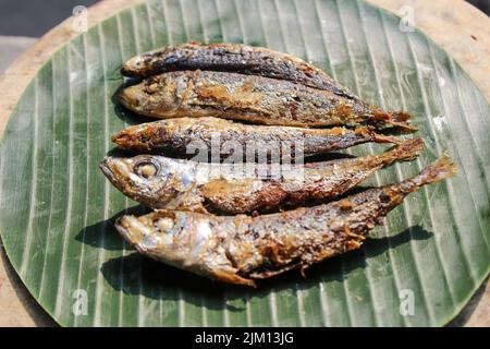 authentique nourriture indonésienne poisson salé frit ou ikan asin gereh sur une surface en bois avec feuille de banane. Banque D'Images