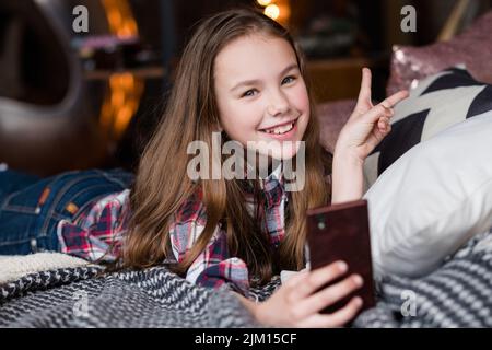 enfant libre fille de loisirs en utilisant le téléphone mobile à la maison Banque D'Images