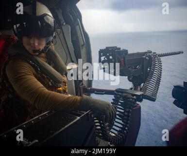 Océan Pacifique. 12th juillet 2022. Naval Aircrewman (hélicoptère) 2nd classe Tyler Williamson, d'Inola, Oklahoma, vole dans un MH-60s Seahawk affecté aux Golden Falcons de l'Escadron de combat de la mer (HSC) 12, embarqué à bord du seul porte-avions déployé par l'avant de la marine américaine, l'USS Ronald Reagan (CVN 76). Le HSC 12, établi à l'origine sous le nom d'Escadron anti-sous-marin d'hélicoptères (HS) 2 sur 7 mars 1952, est le plus ancien escadron d'hélicoptères de la Marine opérationnelle. Ronald Reagan, le navire amiral du Carrier Strike Group 5, fournit une force prête au combat qui protège et défend les États-Unis, un Banque D'Images