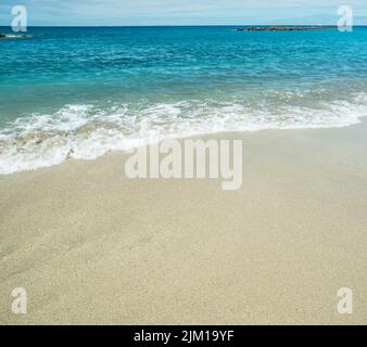 Mousse d'océan couvrant belle longue plage de sable. Banque D'Images