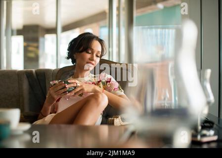 Portrait d'une belle jeune femme asiatique dans un café aime le goût du café du matin. Banque D'Images