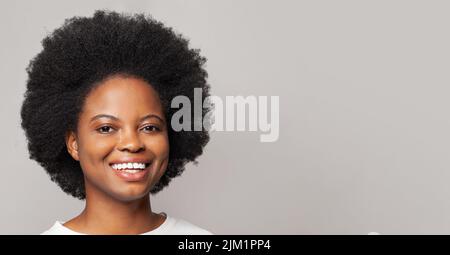 Sympathique gai attrayant curly-cheveux jeune femme souriant agréable, s'amuser, appréciant. Gros plan portrait en studio Banque D'Images