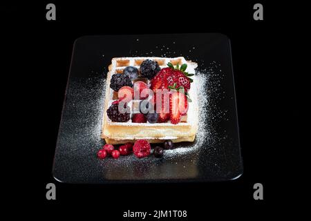 Gaufres belges traditionnelles avec crème glacée et sauce aux fruits rouges sur l'assiette, concentration sélective et espace libre. Photo macro de gaufres avec, bleuets, b Banque D'Images