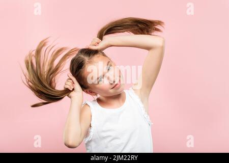 souriant adolescent fille tire queues cheveux sans souci Banque D'Images