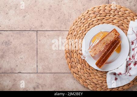 Roch Hachana. Doux nid d'abeilles avec miel, pomme et grenade sur une table en béton rustique beige clair. Fête du nouvel an juif greetin Banque D'Images