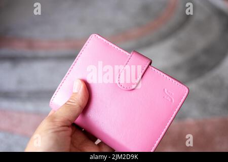 Main féminine tenant un sac à main rose de près Banque D'Images