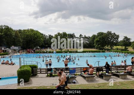 Wacken, Allemagne. 04th août 2022. Les ventilateurs en métal du Wacken Open Air (WOA) se rafraîchissent dans la piscine extérieure. Le WOA est considéré comme le plus grand festival de métaux lourds du monde. Credit: Frank Molter/dpa/Alay Live News Banque D'Images