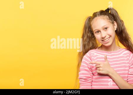 regardez gauche sourire fille point doigt objet virtuel Banque D'Images