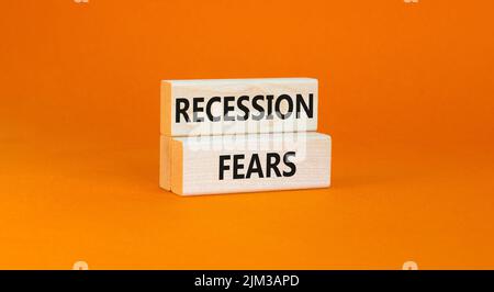 Symbole de la peur de la récession. Mots-clés la récession craint sur des blocs de bois sur un beau fond orange de table. Les entreprises et la récession craignent con Banque D'Images