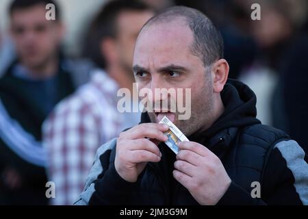 Un homme colle des timbres-poste récemment achetés d'une nouvelle série commémorant la destruction du navire amiral russe Moskva près d'un bureau de poste à Kiev. Le navire amiral de la flotte russe de la mer Noire a été coulé en avril 2022 lors de l'invasion russe de l'Ukraine. Banque D'Images