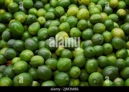 Citrons verts placés sur une étagère pour la vente sur un marché Banque D'Images