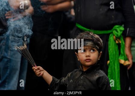 Un garçon musulman chiite cachemirien tient des bâtons d'encens lors d'une procession religieuse le 5th jour de Muharram. Muharram est le premier mois de l'Islam. C'est l'un des mois les plus saints du calendrier islamique. Les musulmans chiites commémorent Muharram comme un mois de deuil en souvenir du martyre du petit-fils du prophète islamique Muhammad Imam Hussain, qui a été tué à Ahura (10th jour de Muharram) dans la bataille de Karbala en 680 A.D. Banque D'Images