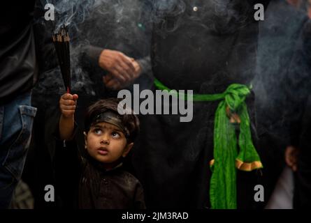 Un garçon musulman chiite cachemirien tient des bâtons d'encens lors d'une procession religieuse le 5th jour de Muharram. Muharram est le premier mois de l'Islam. C'est l'un des mois les plus saints du calendrier islamique. Les musulmans chiites commémorent Muharram comme un mois de deuil en souvenir du martyre du petit-fils du prophète islamique Muhammad Imam Hussain, qui a été tué à Ahura (10th jour de Muharram) dans la bataille de Karbala en 680 A.D. Banque D'Images