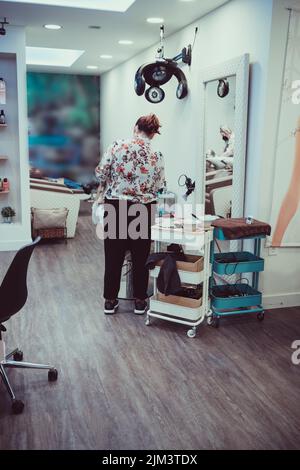 Femme blonde mourant ses cheveux dans le salon de beauté. Gros plan de sa coloration de cheveux. Utilisation d'une feuille d'aluminium pour mettre en évidence. Banque D'Images