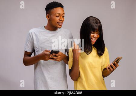 Le portrait d'un couple africain s'est concentré et a utilisé des gadgets espionnant pour discuter de l'affaire de tricherie a buté Banque D'Images