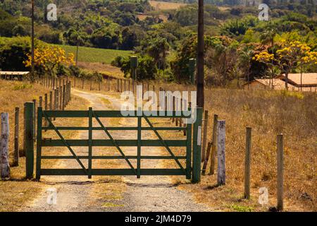 Goiania, Goiás, Brésil – 24 juillet 2022 : une porte en bois peint en vert à l'entrée d'une ferme sur le côté d'une autoroute à Goias. Banque D'Images