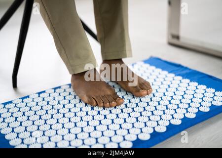 Tapis d'acupression et équipement de soins corporels d'acupuncture. Pieds mâles Banque D'Images