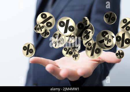 Une main d'homme d'affaires sur un arrière-plan flou en utilisant 3D icônes de pourcentage de ventes de rendu Banque D'Images