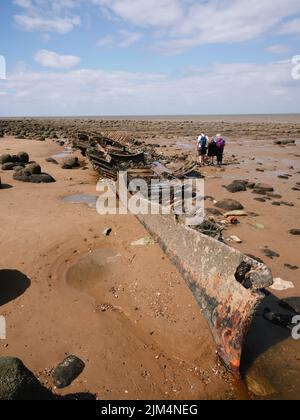 Touristes à une épave d'un vieux navire sur la plage de Hunstanton paysage de côte en été à marée basse nord Norfolk Angleterre Royaume-Uni Banque D'Images