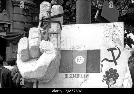 Bucarest, Roumanie, janvier 1990. « Golaniada », une importante manifestation anti-communiste sur la place de l'université après la révolution roumaine de 1989. Les gens se rassembleraient tous les jours pour protester contre les ex-communistes qui ont pris le pouvoir après la Révolution. Sur cette photo, la rose, symbole du nouveau parti au pouvoir, F.S.N., est associée au symbole communiste. Une grande main a été attachée de sorte qu'il ne sera pas en mesure de faire le signe de la victoire, en allusion que la victoire dans la révolution a été volé au peuple. Banque D'Images