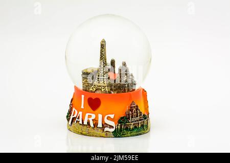 Gros plan d'un souvenir de boule à neige de la Tour Eiffel de Paris isolé sur fond blanc Banque D'Images