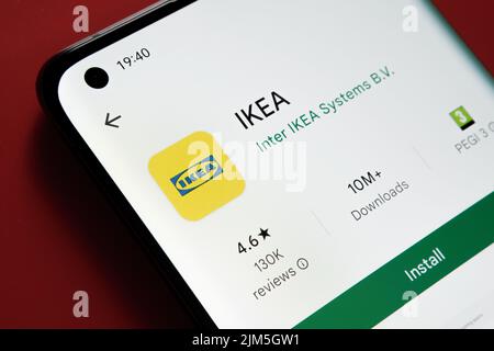 Application IKEA vue dans Google Play Store sur l'écran du smartphone placé sur fond rouge. Gros plan avec mise au point sélective. Stafford, Royaume-Uni, A Banque D'Images