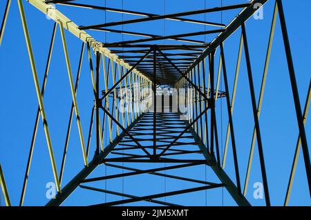 Vue intérieure d'un pylône haute tension. Structures d'une tour en treillis d'une ligne électrique à Francfort, en Allemagne. Acier dans le ciel bleu du soir. Banque D'Images