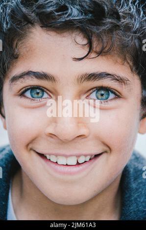 Portrait vertical d'un jeune garçon souriant avec des yeux bleus Banque D'Images