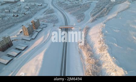 Une vue aérienne d'une zone enneigée avec des immeubles et une route s'étendant le long Banque D'Images