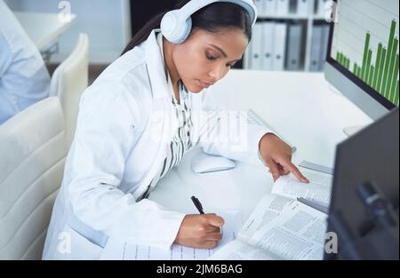 Les réponses que nous recherchons, la science nous donnera. Un jeune scientifique effectuant des recherches dans un laboratoire. Banque D'Images