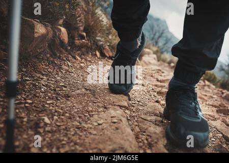 Une promenade dans la nature marche l'âme de retour à la maison. Gros plan d'un homme méconnaissable utilisant un poteau de marche tout en marchant dans les montagnes. Banque D'Images