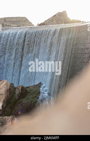 un cliché vertical d'une chute d'eau qui éclabousse les rochers Banque D'Images