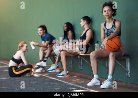 Avec cette équipe, tout est possible. Portrait en longueur d'une jeune athlète féminine attirante assise sur un banc au terrain de basket-ball avec elle Banque D'Images