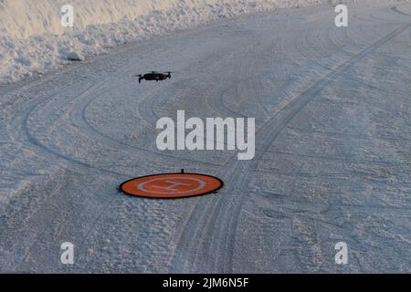 La vue du drone volant et d'un débarcadère orange sur le sol recouvert de neige. Banque D'Images