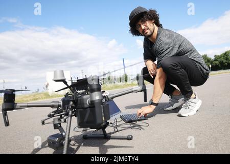 Aldenhoven, Allemagne. 27th juillet 2022. Mohamed Azzahhafi, pilote de drone au laboratoire d'innovation de Vodafone, prépare le drone DJI Matrice 210 RTK. Prêt pour le décollage au laboratoire de mobilité Vodafone 5G. Il y a une règle de base pour les drones : vous ne pouvez les voler que si vous les voyez. Pourquoi ? 5G les communications mobiles pourraient assurer des connexions sans secousses - et le pilote pourrait élargir son champ de vision, pour ainsi dire. (À dpa: 5G dans l'utilisation de drone: L'industrie des télécommunications vante les avantages) Credit: Oliver Berg/dpa/Alamy Live News Banque D'Images