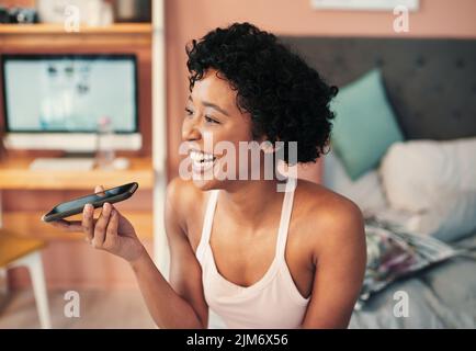 La technologie est devenue une grande partie de notre vie quotidienne, une jeune femme utilisant un téléphone portable à la maison. Banque D'Images