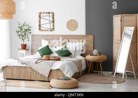 Intérieur d'une chambre confortable avec poufs en rotin et miroir Banque D'Images