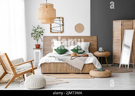 Intérieur d'une chambre confortable avec poufs en rotin et miroir Banque D'Images