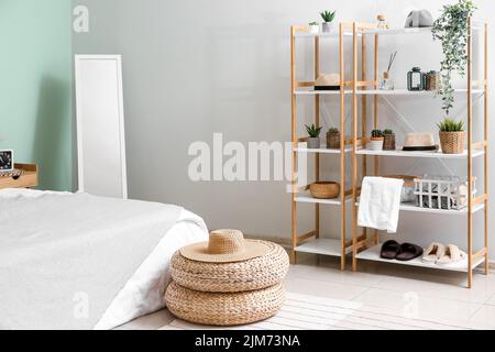 Intérieur d'une chambre confortable avec poufs en rotin, miroir et étagère Banque D'Images