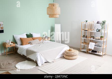 Intérieur d'une chambre confortable avec poufs en rotin, miroir et étagère Banque D'Images