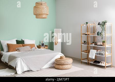 Intérieur d'une chambre confortable avec poufs en rotin, miroir et étagère Banque D'Images