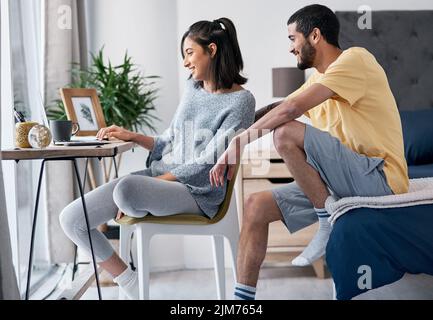 Apprendre à connaître une nouvelle façon de travailler. Un jeune couple heureux qui travaille de chez lui. Banque D'Images