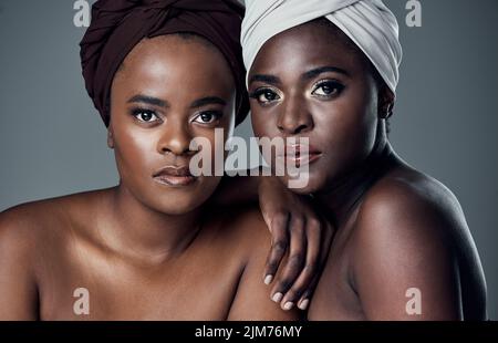 Nous avons su préserver notre magnifique patrimoine et nos traditions. Studio portrait de deux belles jeunes femmes posant sur un fond gris. Banque D'Images